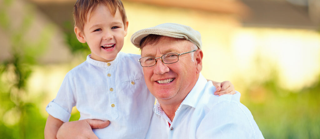 man wearing eyeglasses, hugging his grandchild