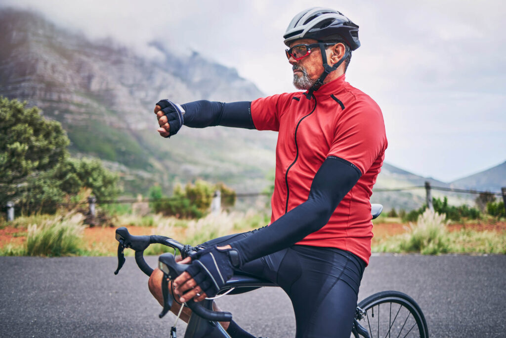 A man on a bicycle checks his heart rate.