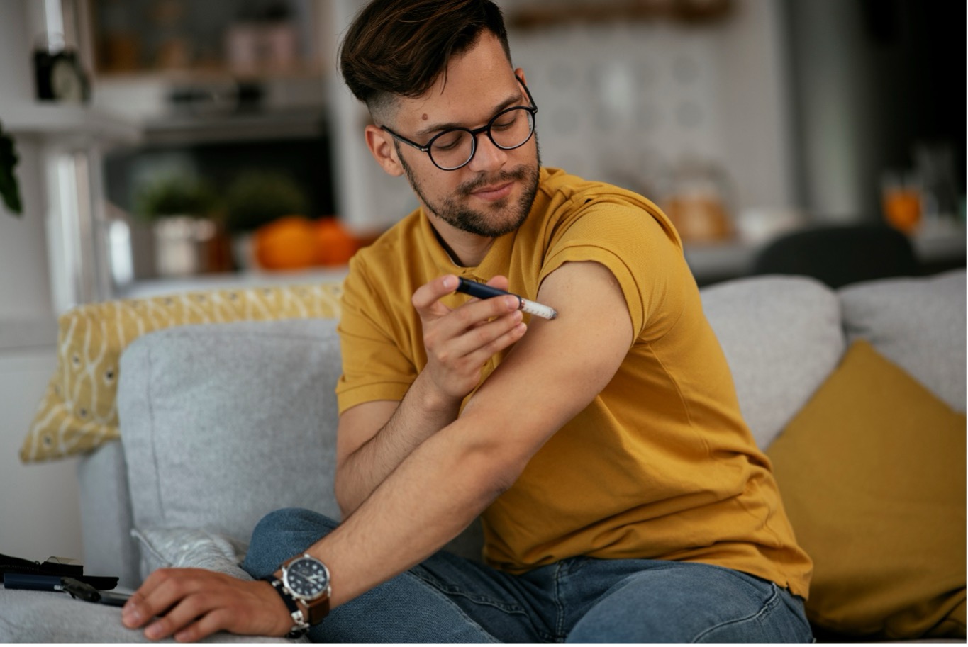 A man injects insulin into his upper arm.