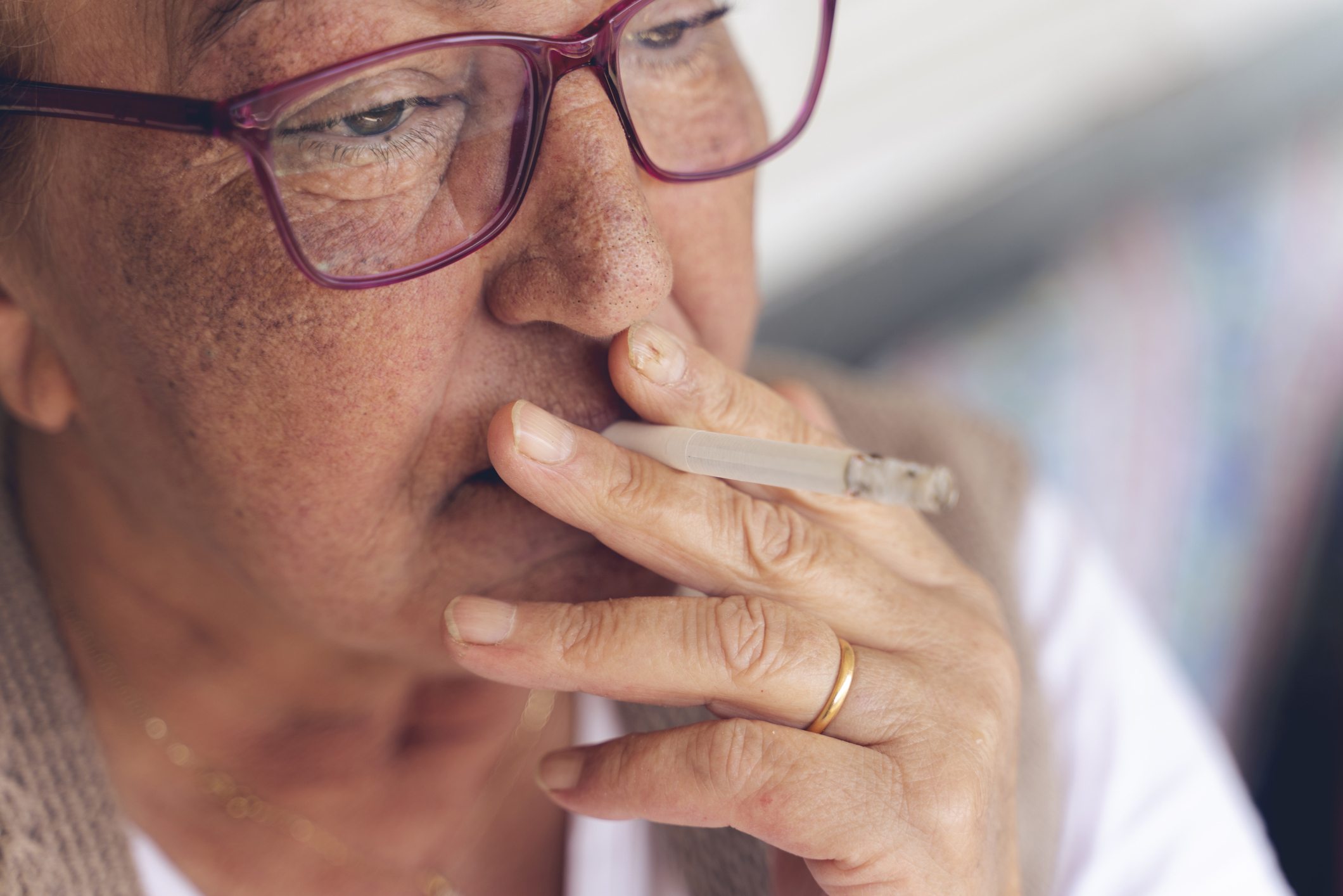 Woman wearing glasses smoking a cigarette